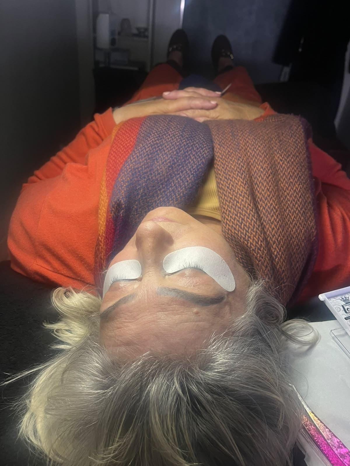 Client relaxing during an eyelash extension appointment